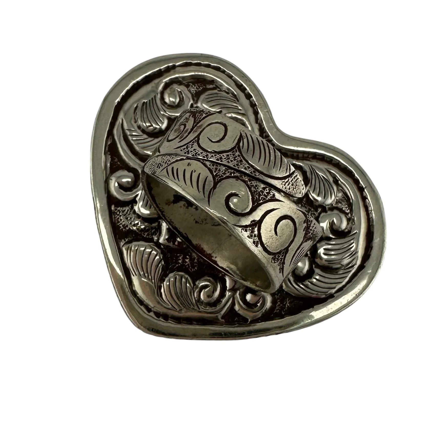 rear view of decorative silver ring with intricate designs on a heart-shaped base
