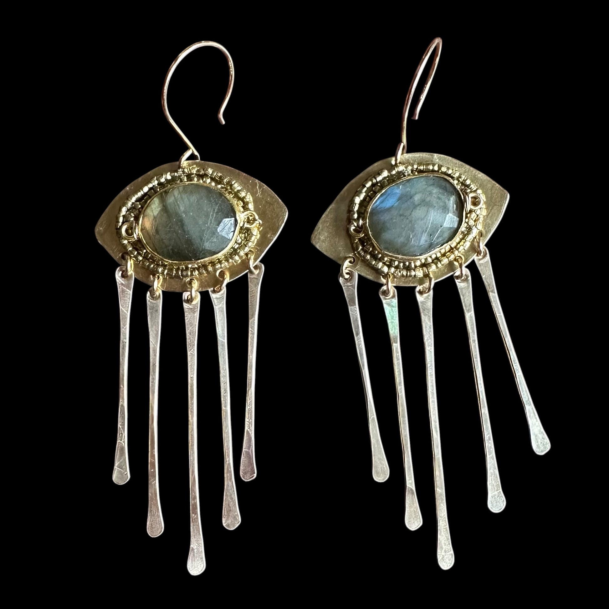 Pair of earrings with gold and silver design on a black background