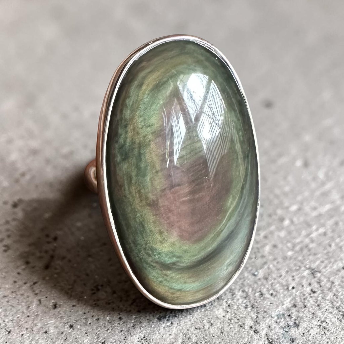 Rainbow obsidian ring in Sterling Silver on textured background 