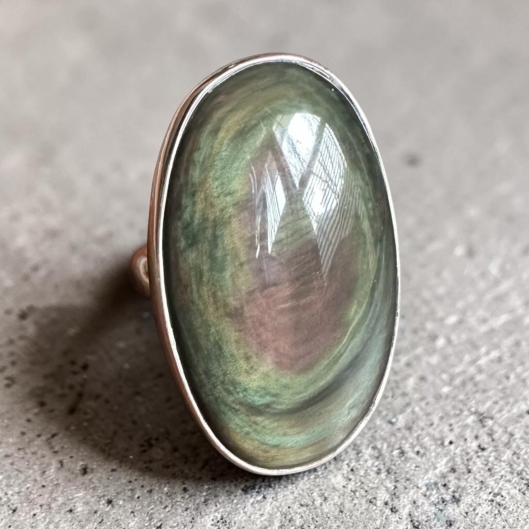 Rainbow obsidian ring in Sterling Silver on textured background 
