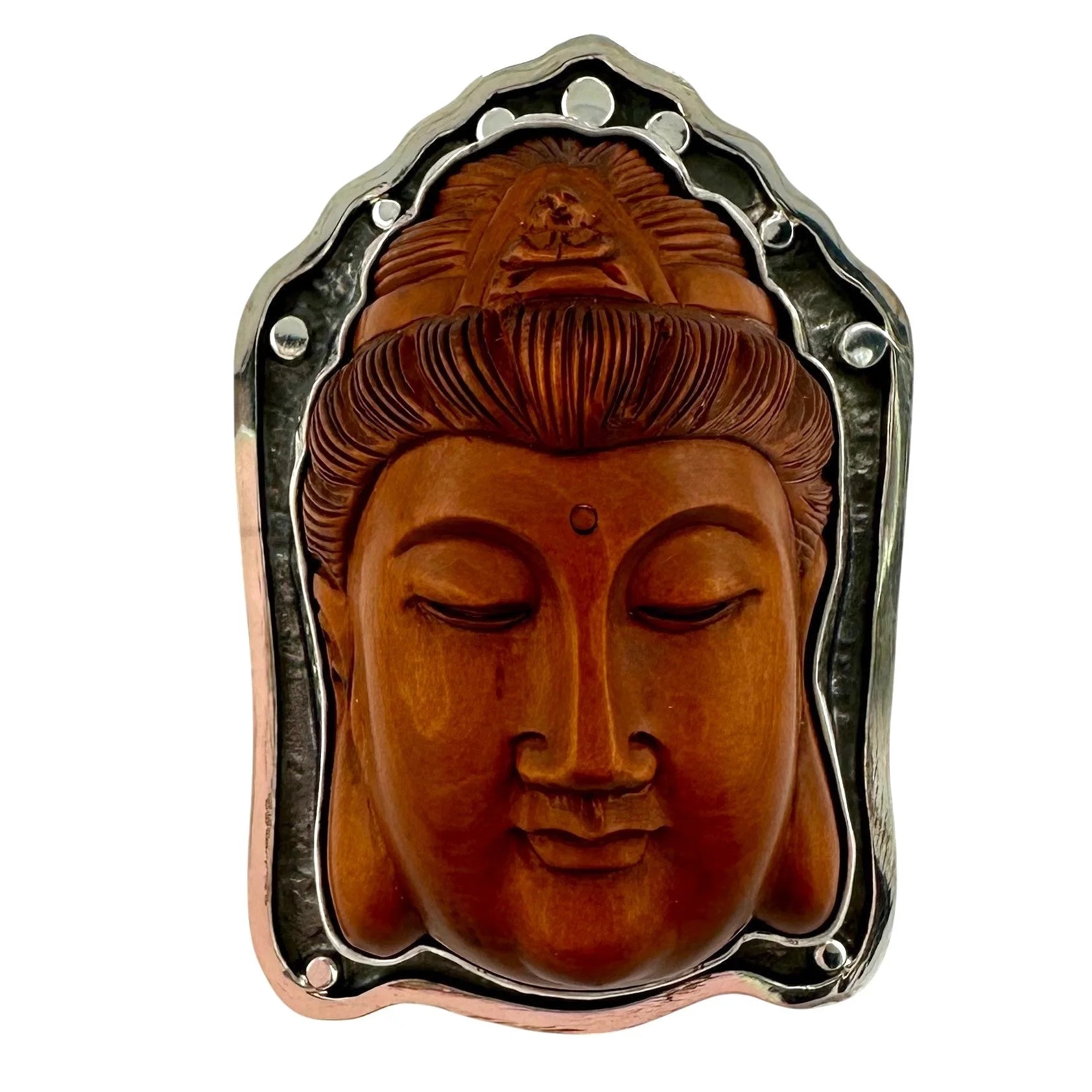 Carved wooden Buddha face with hand tooled silver ring on a white background