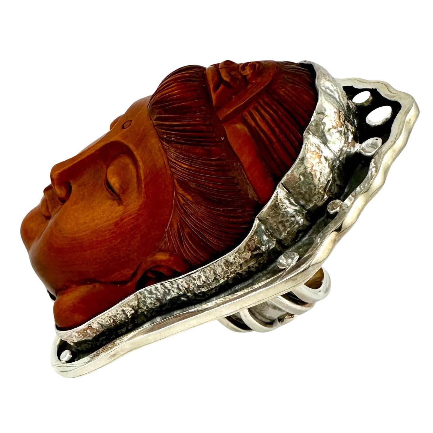 Carved wooden Buddha face in silver ring setting on a white background