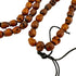 Wooden handmade beaded skull necklace with a tassel on a white background