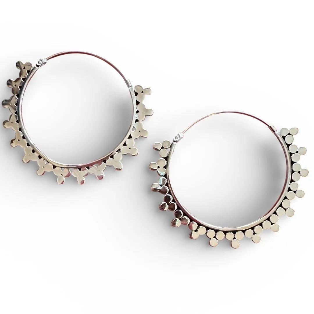 Pair of Indonesian silver hoop earrings on a white background