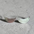 Silver hoop earrings with half-circle design on a gray surface