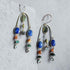 Multicolored semi-precious stone beaded handmade brass earrings on a textured gray surface