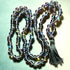 Crystal beaded necklace with a tassel on a light green background
