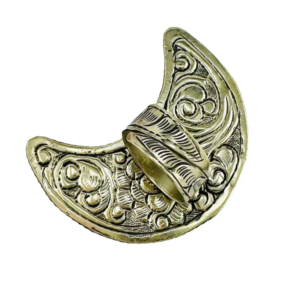 Large crescent moon ring with intricate hand tooled patterns on the back on a white background