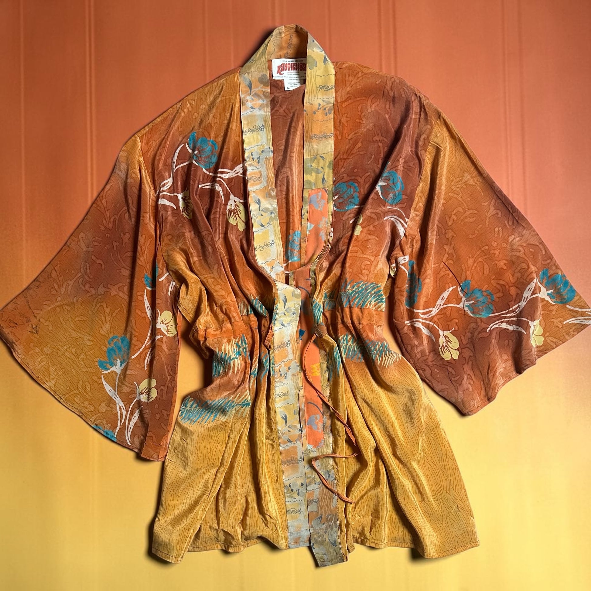 Kantha Bae vintage style kimono with floral patterns on a yellow and orange gradient background