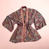Floral-patterned kimono with a burgundy belt on a light pink background