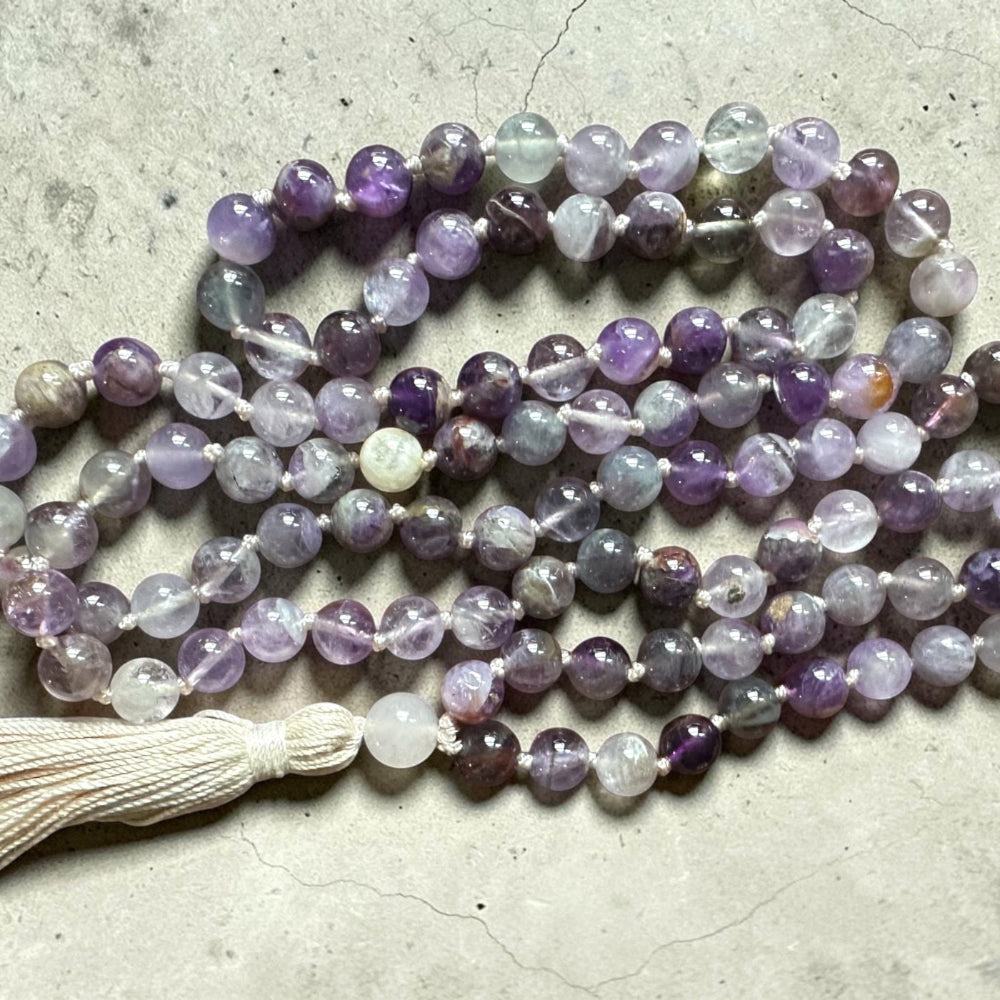 Meditation  mala necklace with multicolored beads on a textured surface