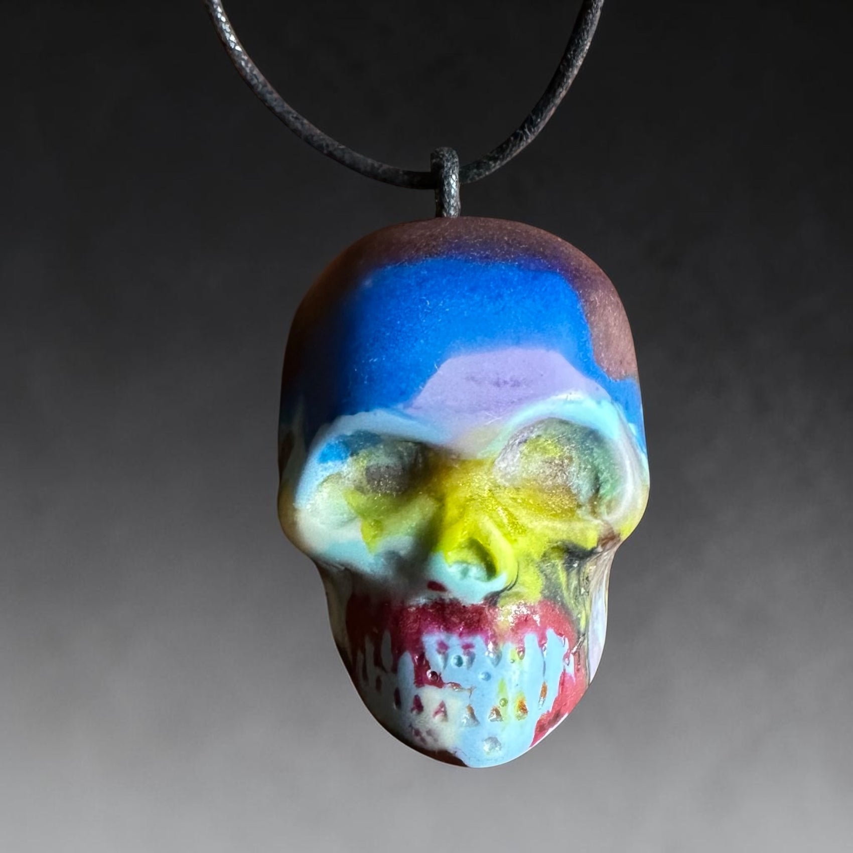 Colorful skull-shaped pendant on a dark background