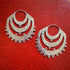 Pair of Indonesian tribal silver hoop earrings with small spherical accents on a red wooden surface